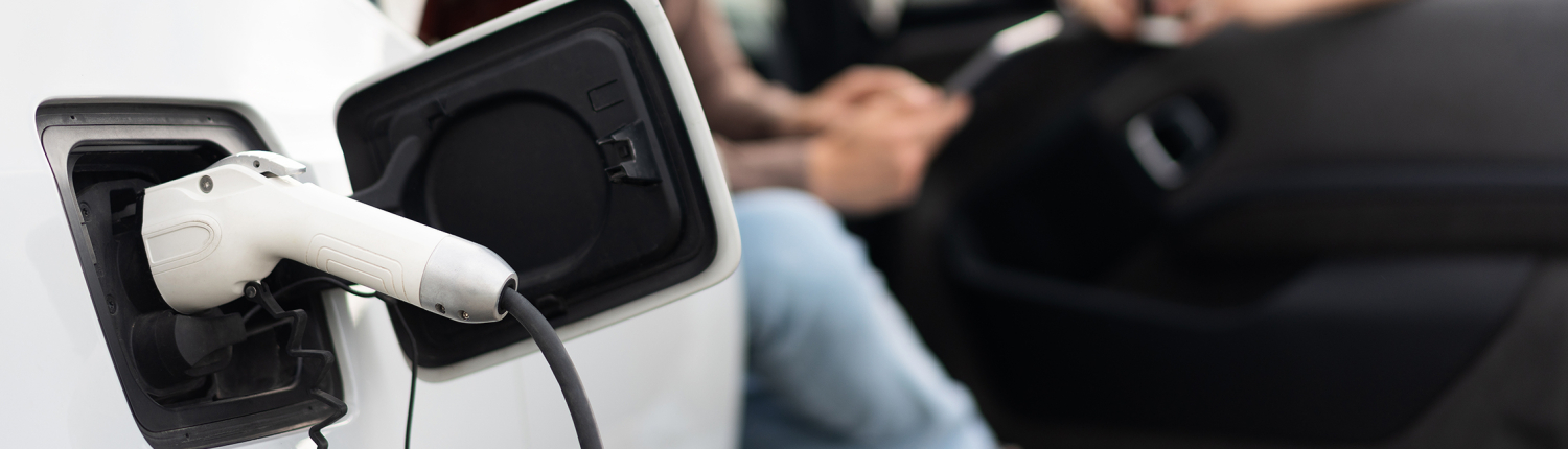 Conversation Near Charging Electric Vehicle Outside Modern Home